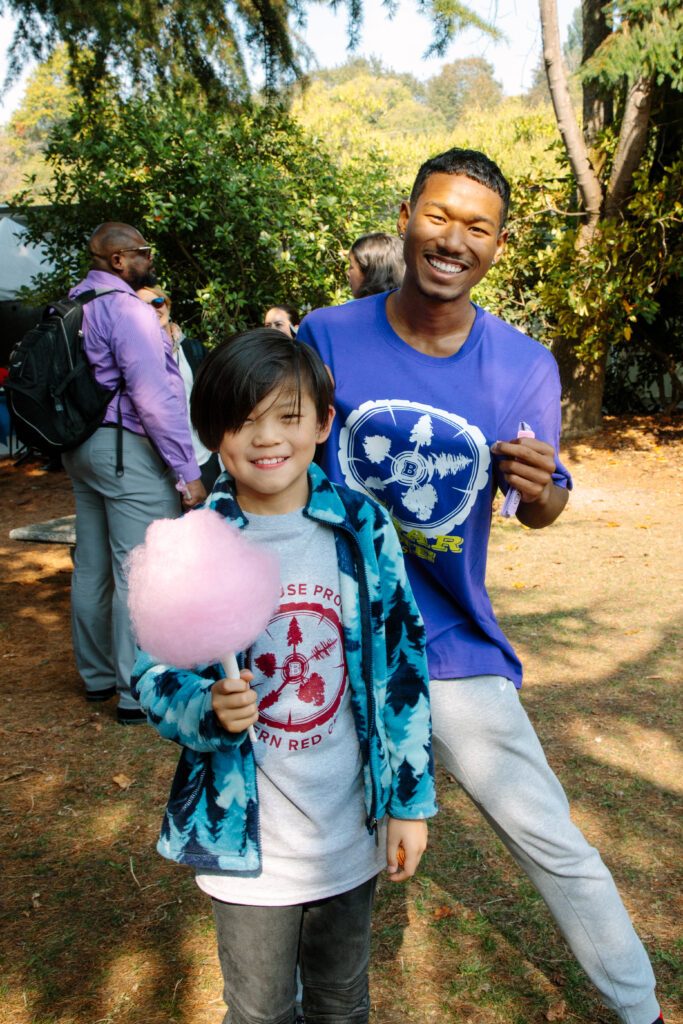 Photograph of a man with a young student holding cotton candy.